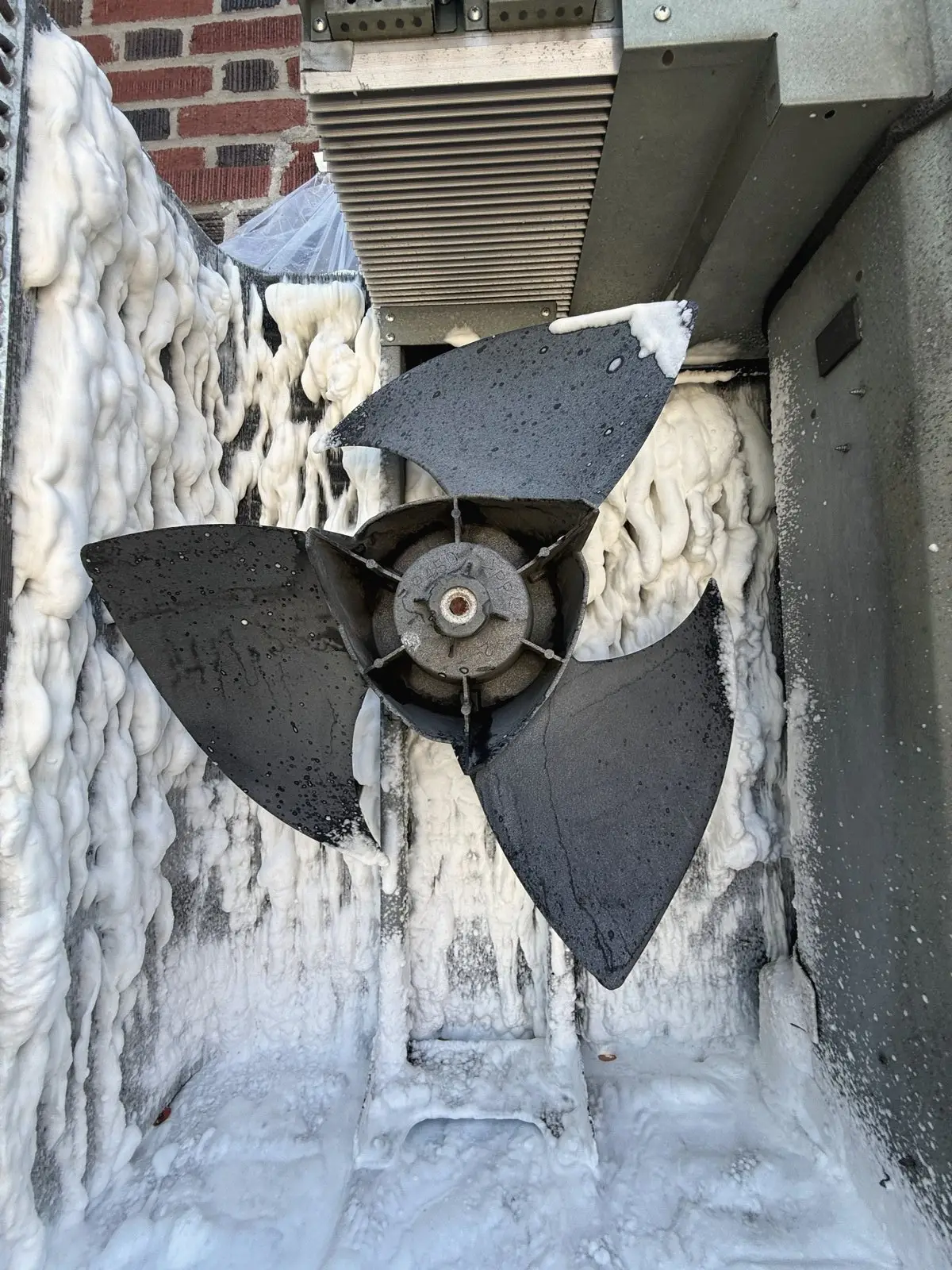 Iced-over condenser fan on a New York winter service call